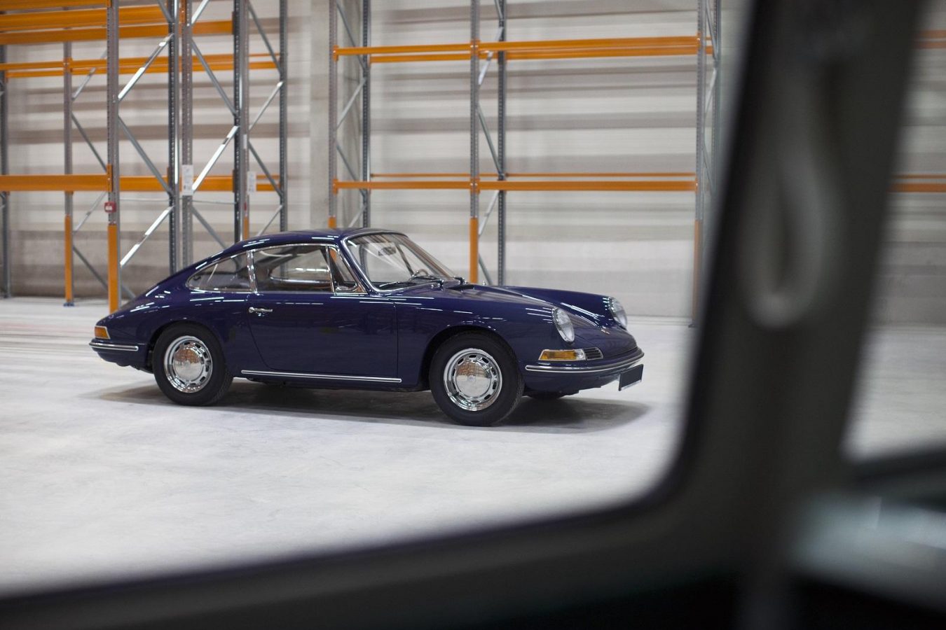 Blauer von der Seite Porsche 911 SWB vor Lagerregalen